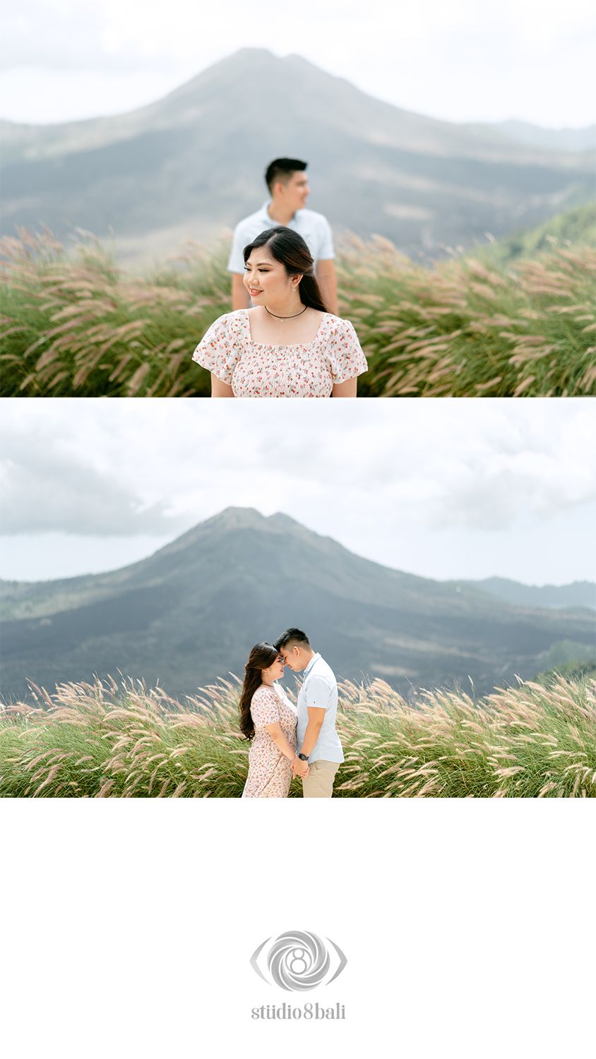 Couple poses romantically in tall grass with Mount Batur volcano backdrop during Bali pre-wedding photoshoot.