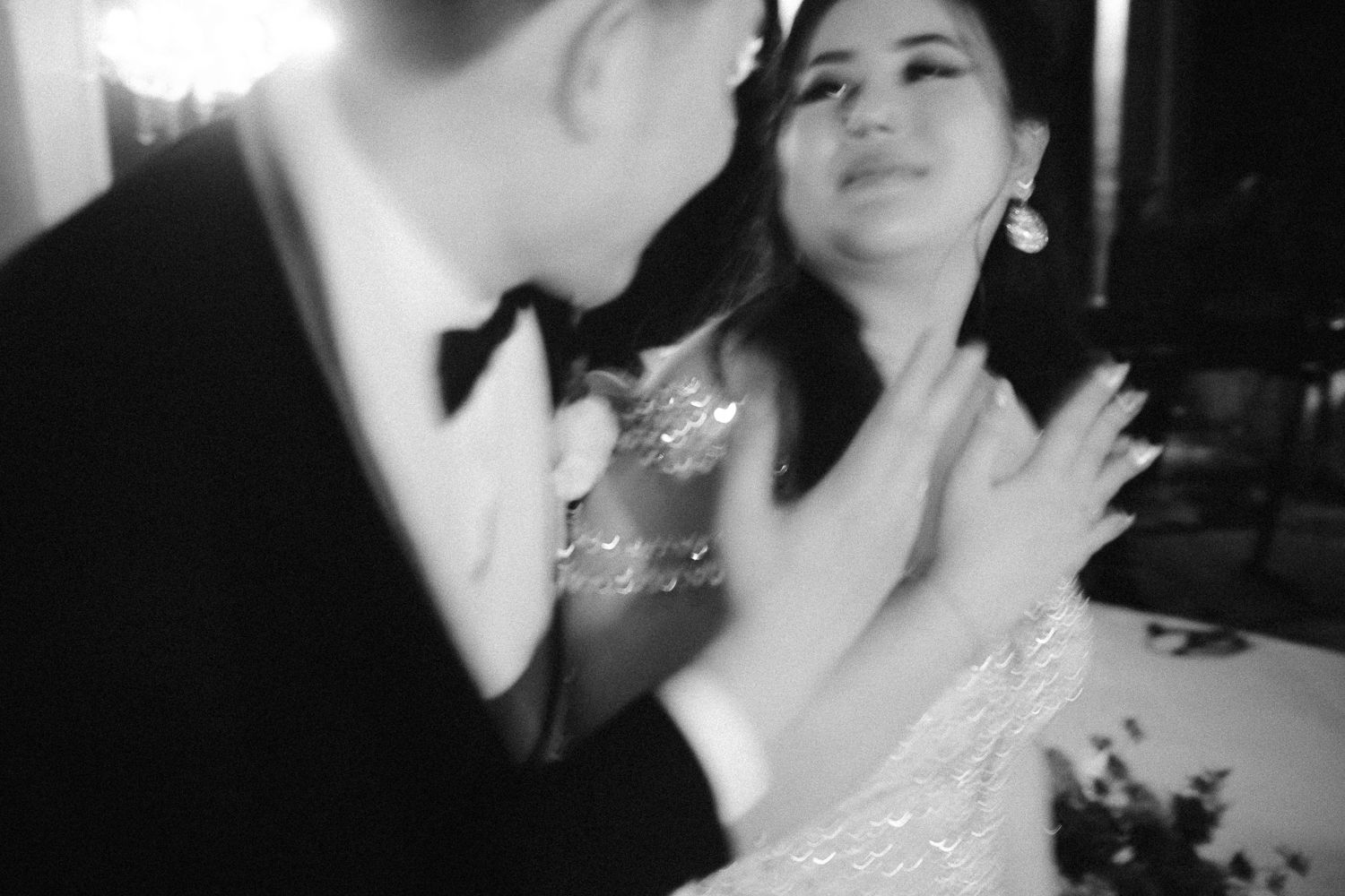 Black and white photo of a couple sharing a romantic dance at a formal wedding reception event.