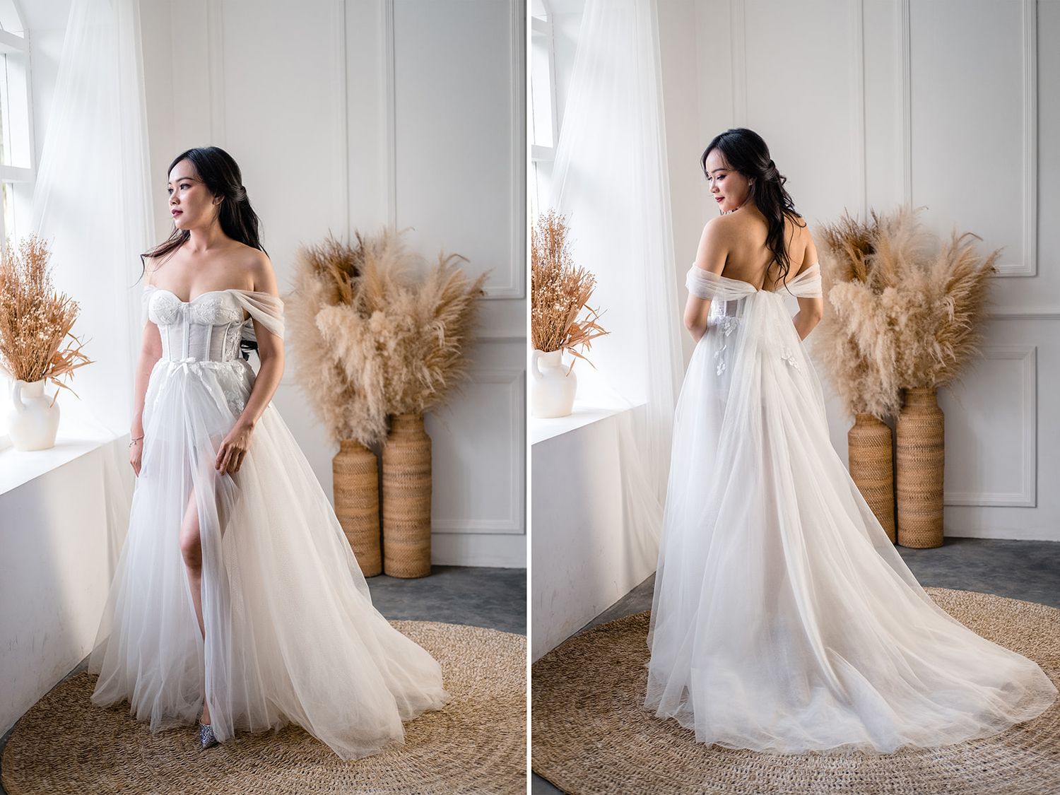 Elegant bride in a white off-shoulder tulle wedding gown with a slit, posing in a bright room with pampas grass decor.
