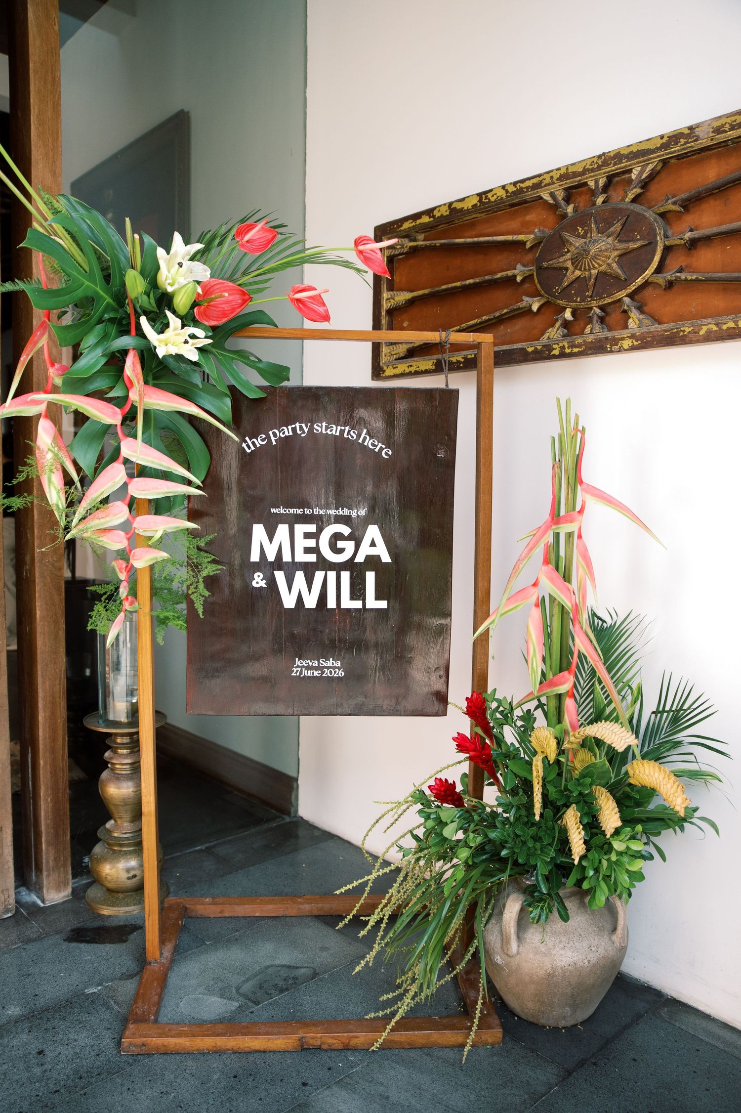 Wedding welcome sign for Mega and Will decorated with tropical flowers in Bali venue.