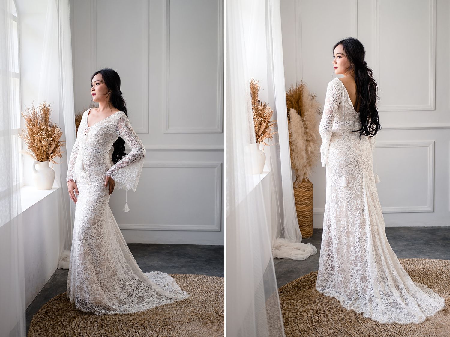 Elegant bride in white lace mermaid wedding gown with long sleeves, posing by a window in a bright studio.