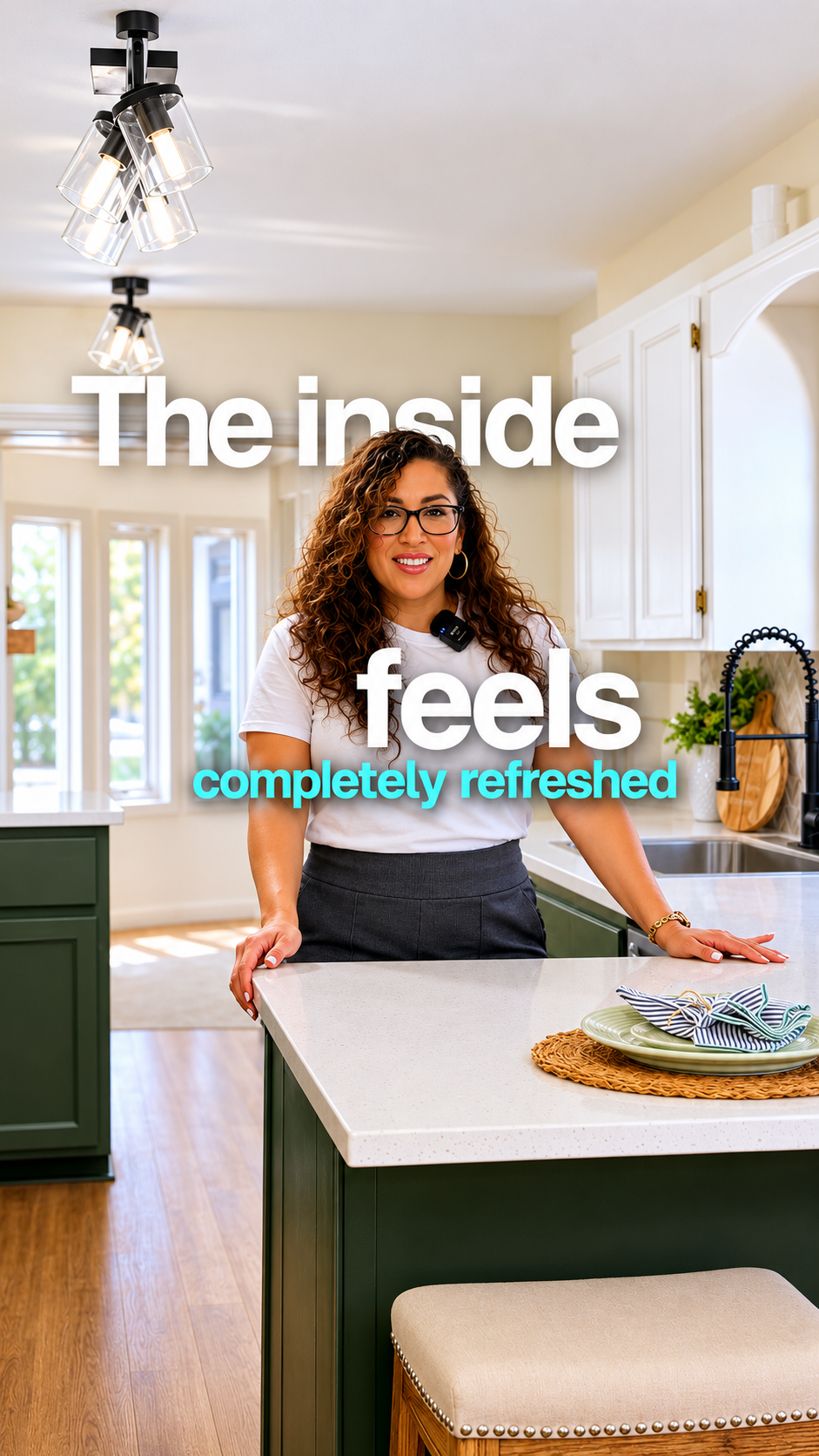 Woman standing in refreshed kitchen with green island, white cabinets, and modern lighting.
