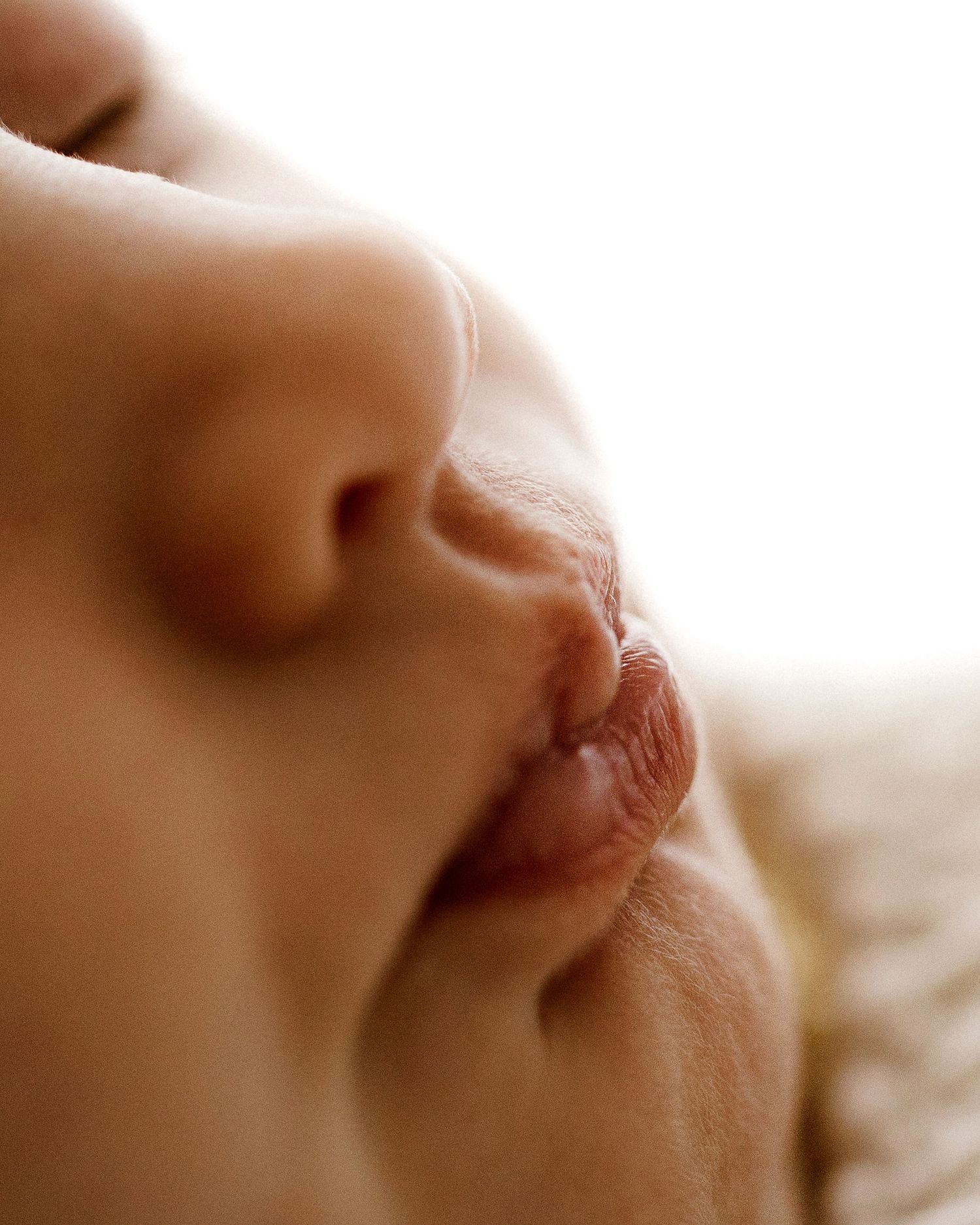 Extreme close-up macro photo of a sleeping newborn baby's nose and lips.