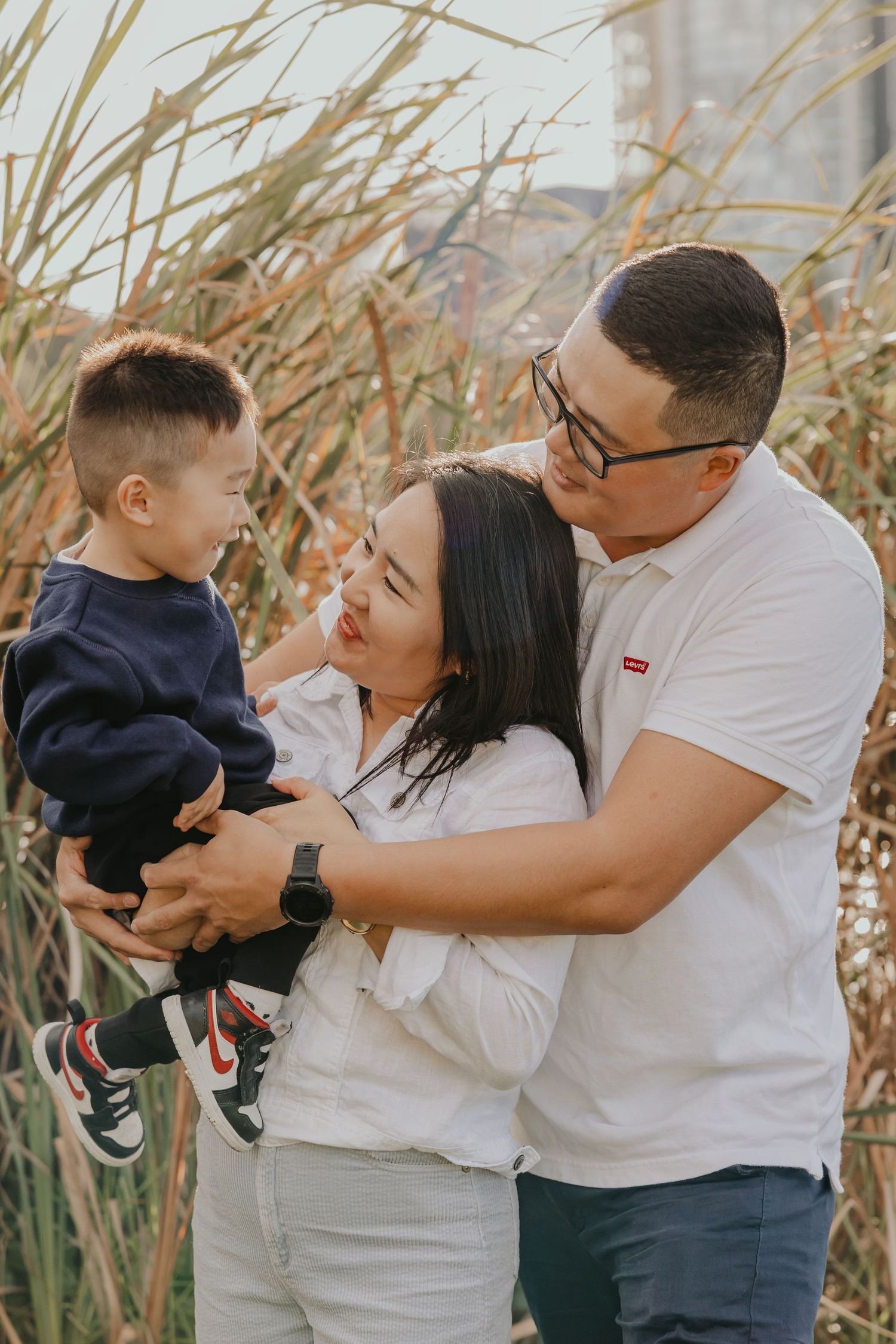 Family portrait hugging in tall grass outdoors, Sydney family photographer