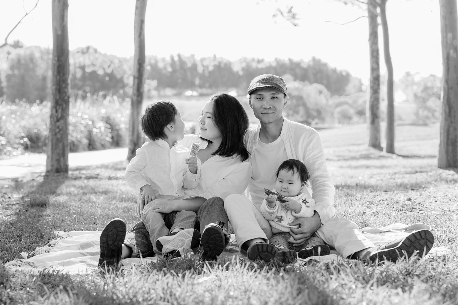 Black and white outdoor family portrait sitting on grass, Sydney family photographer