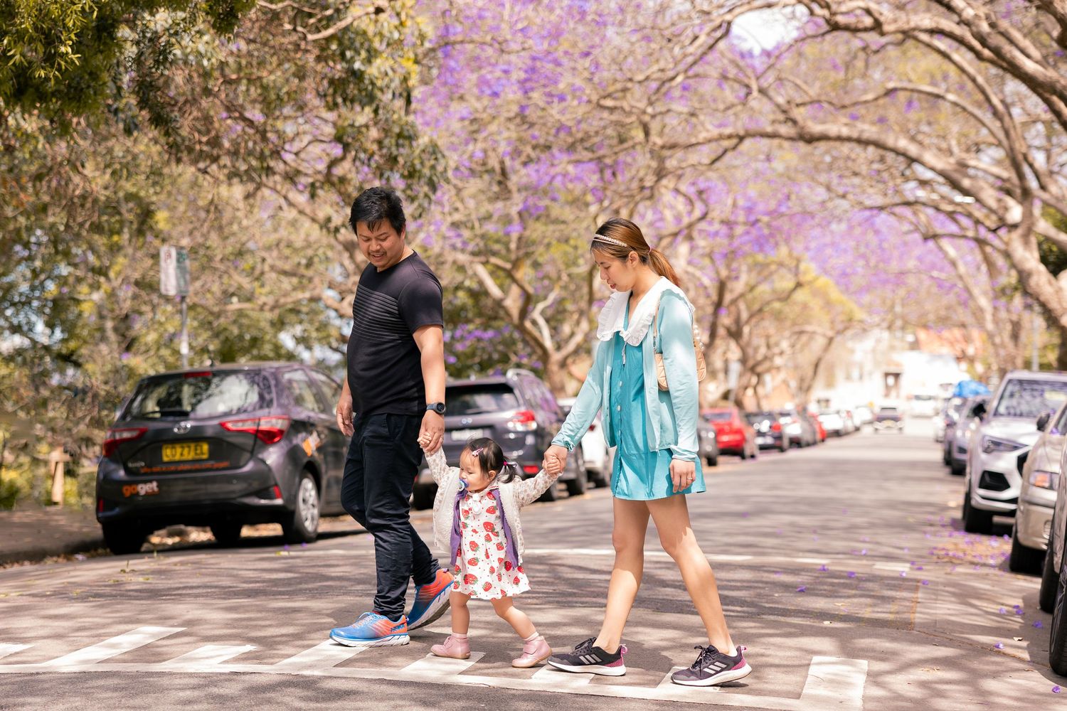 Family walking outdoors under blooming trees, Sydney family photography session