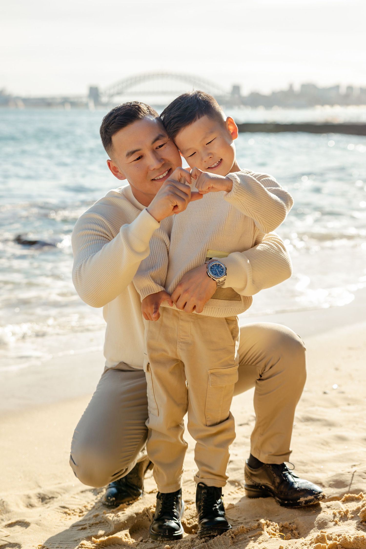 Father holding child on beach during family session, Sydney family photographer