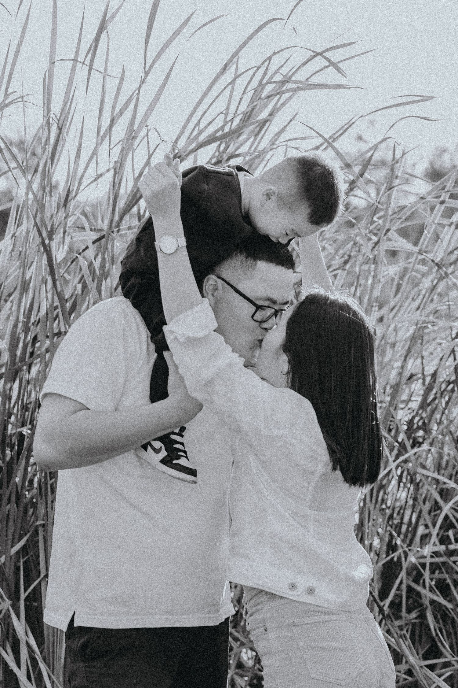 Black and white outdoor couple portrait in tall grass, Sydney maternity photographer