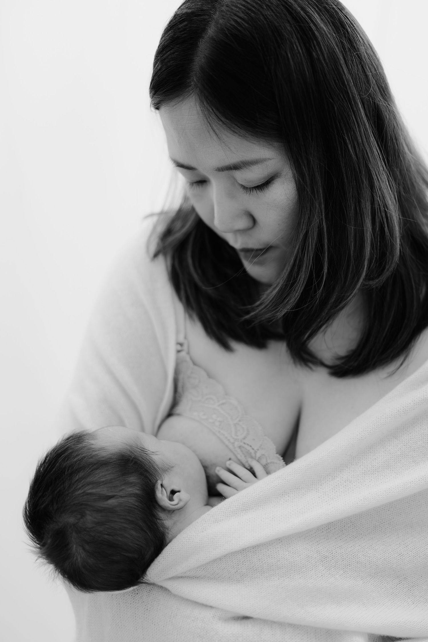 Black and white portrait of a mother holding her newborn baby, at home newborn session Sydney