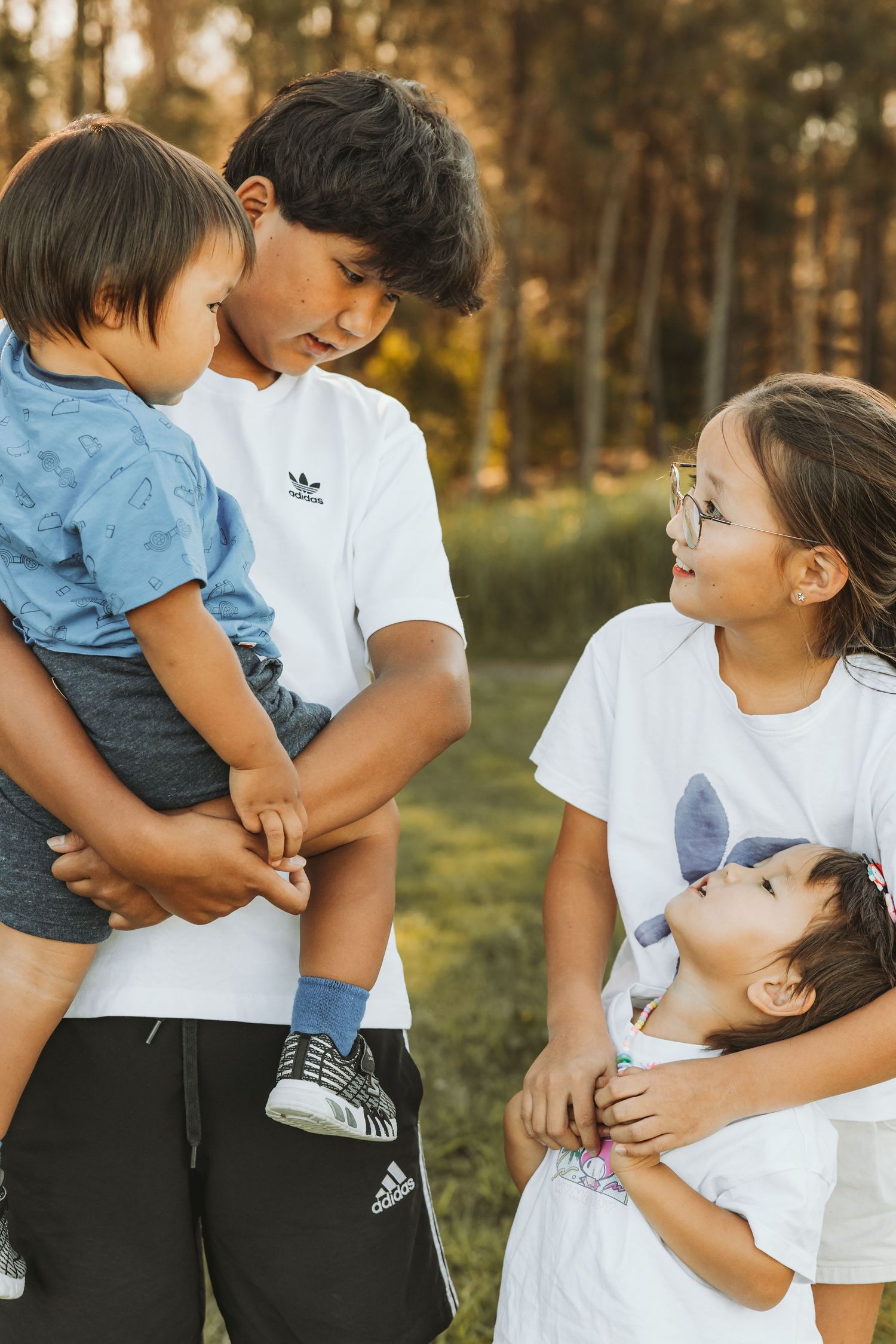 Family portrait outdoors with parents holding children, Sydney outdoor family photographer