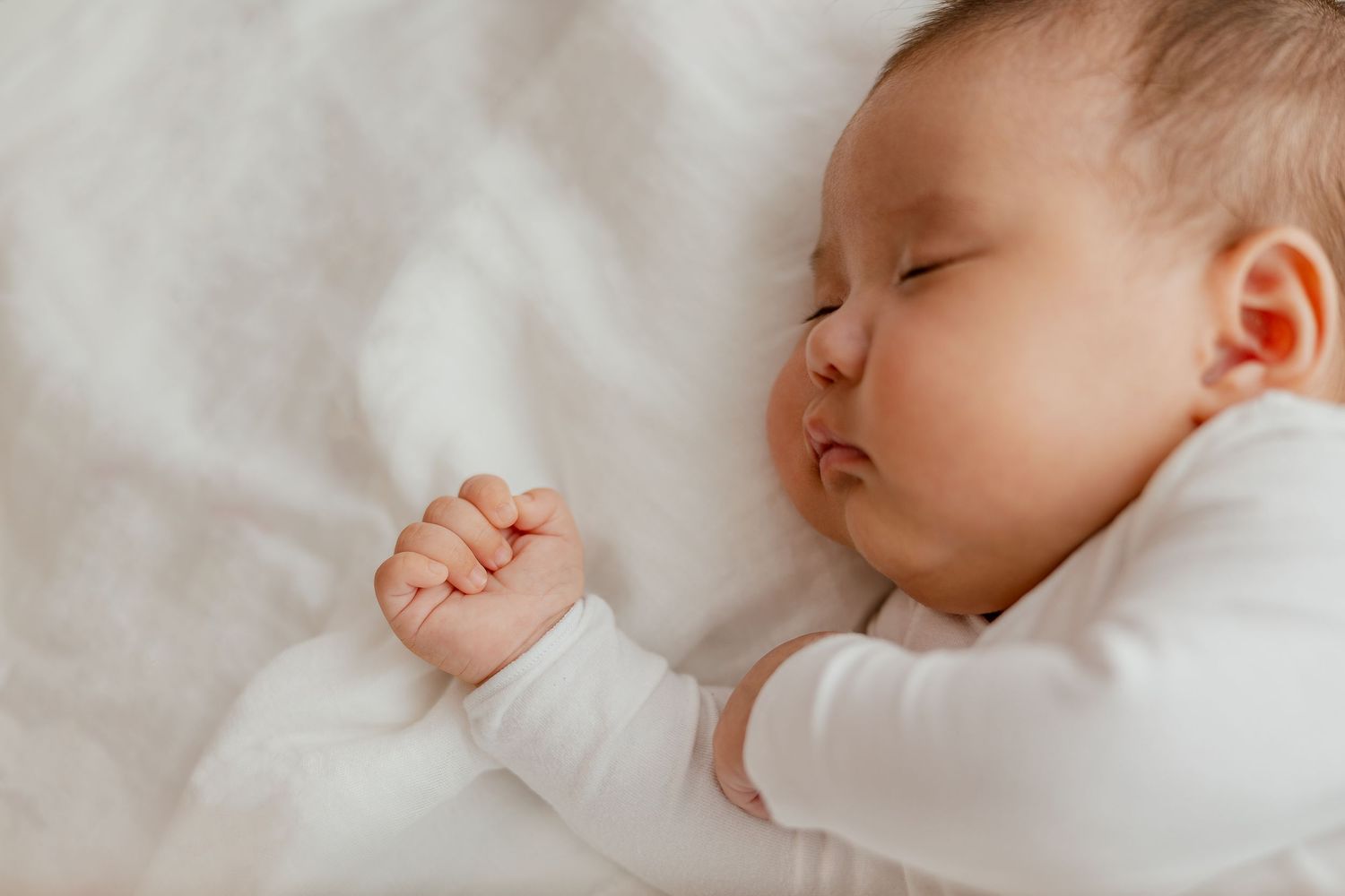 Newborn baby sleeping in soft natural light, Sydney newborn lifestyle session