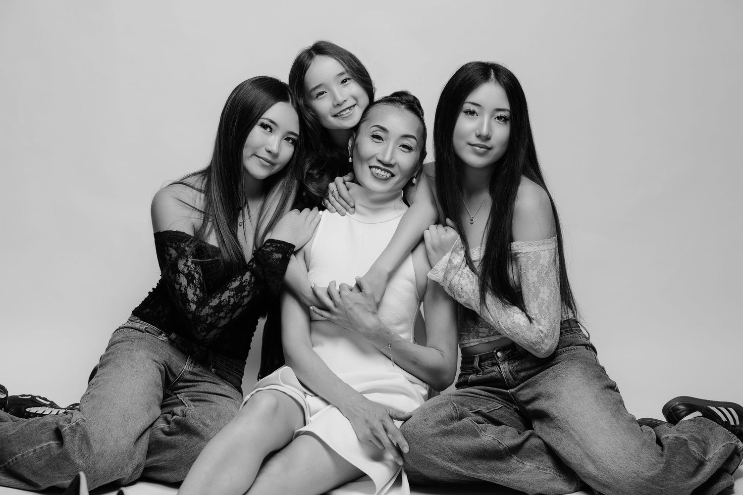 Black and white studio portrait of four women sitting together, Sydney portrait photographer