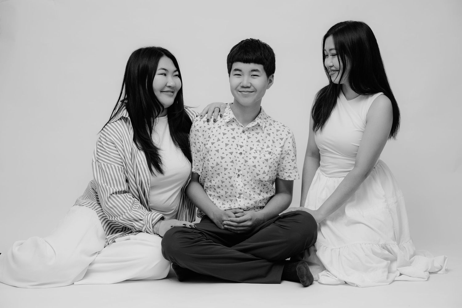 Black and white studio family portrait sitting together, Sydney studio photographer