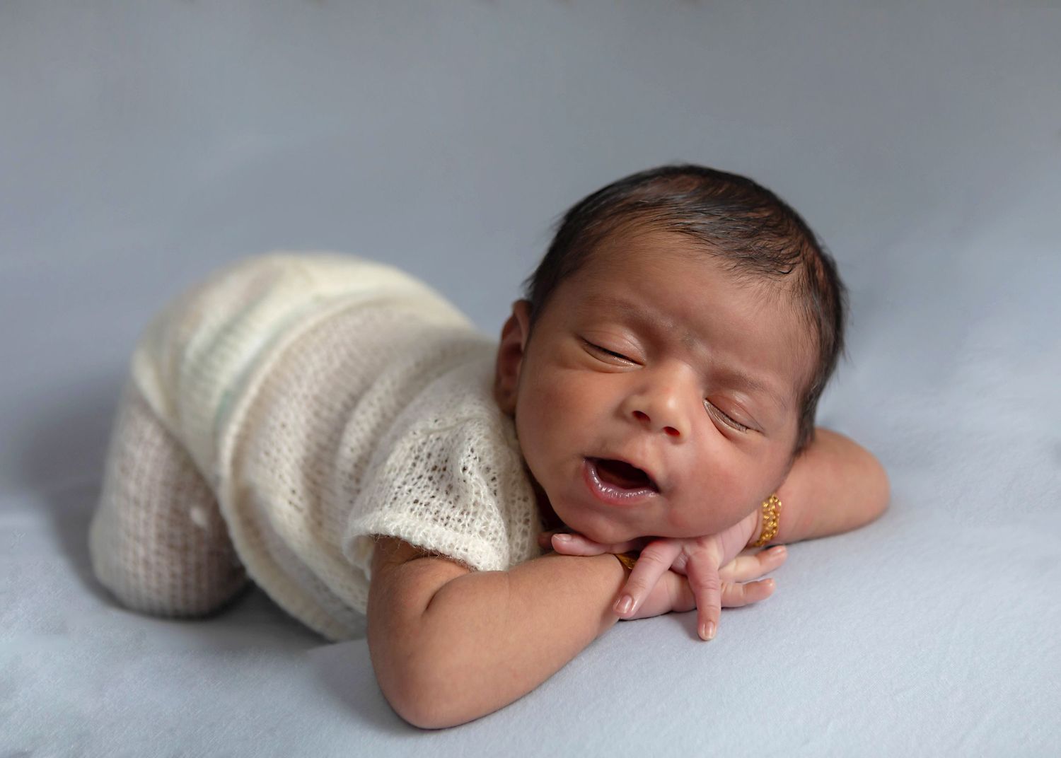 Newborn baby boy styled in simple classic posing