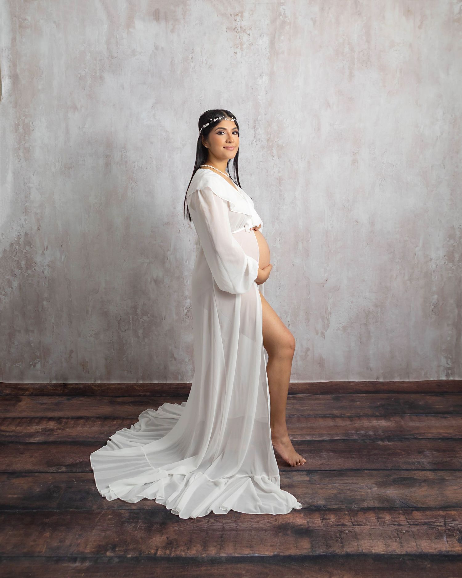 Pregnant mama wearing white posing with textured white backdrop