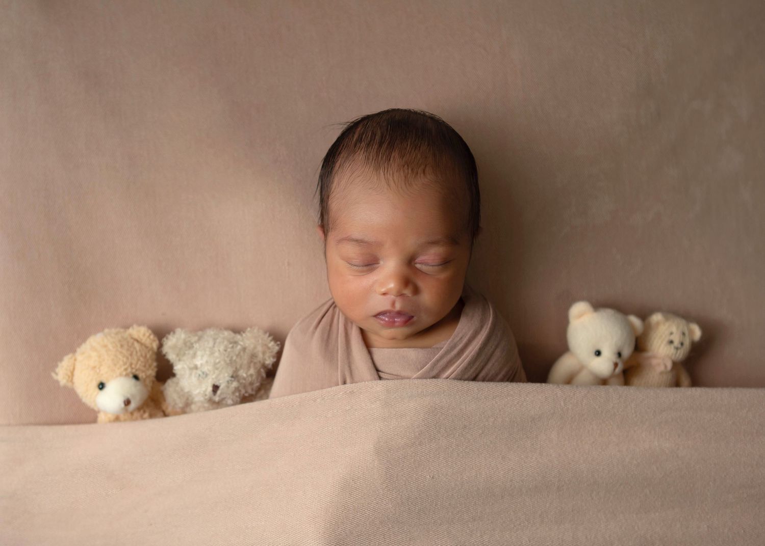 Newborn baby boy styled with small bears