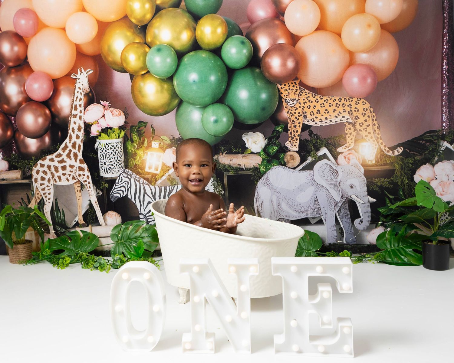 Safari themed backdrop. Baby boy in bathtub