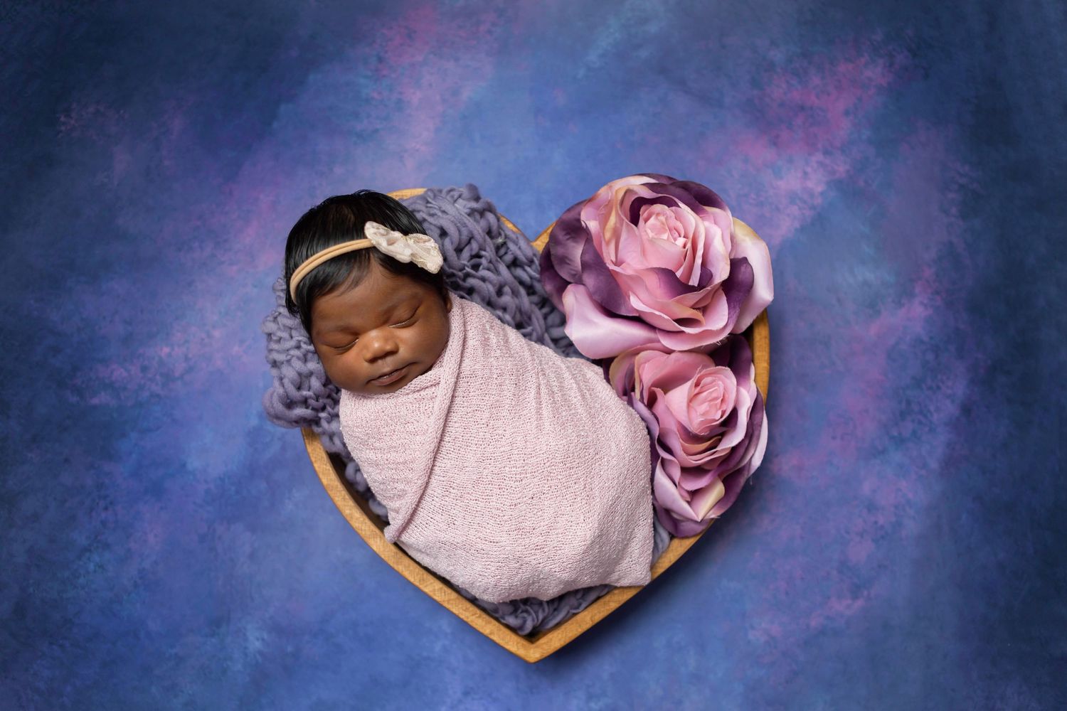 baby girl posed in newborn heart prop