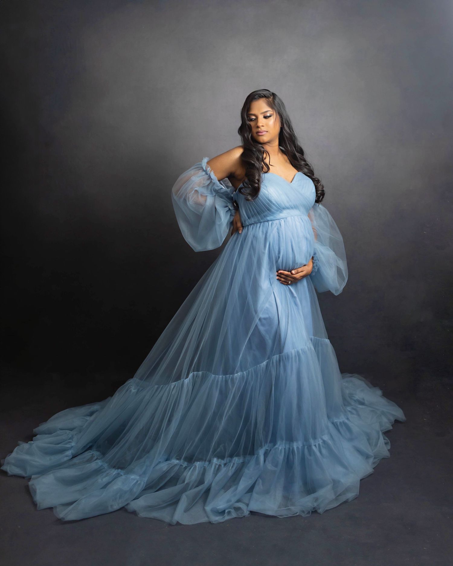Pregnant boy mom in blue against a charcoal backdrop