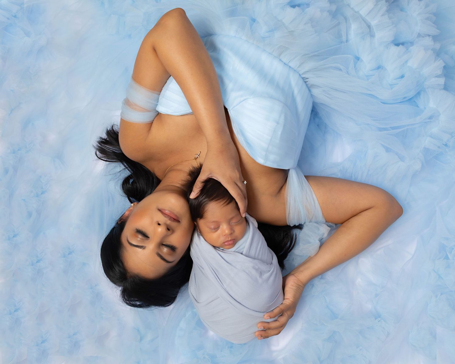 New mom and newborn baby posing lying on the floor