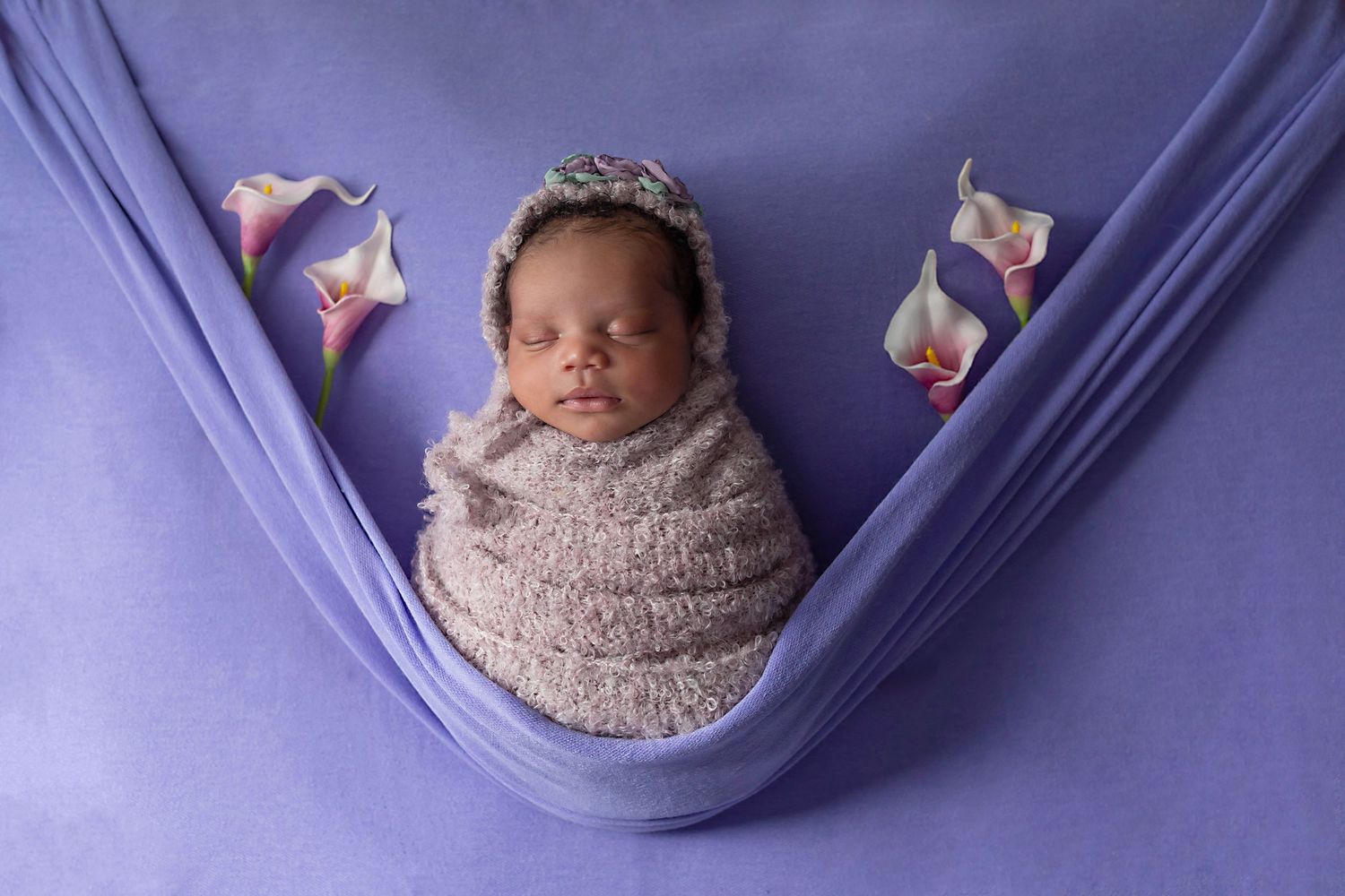 Newborn baby beautifully styled in studio props