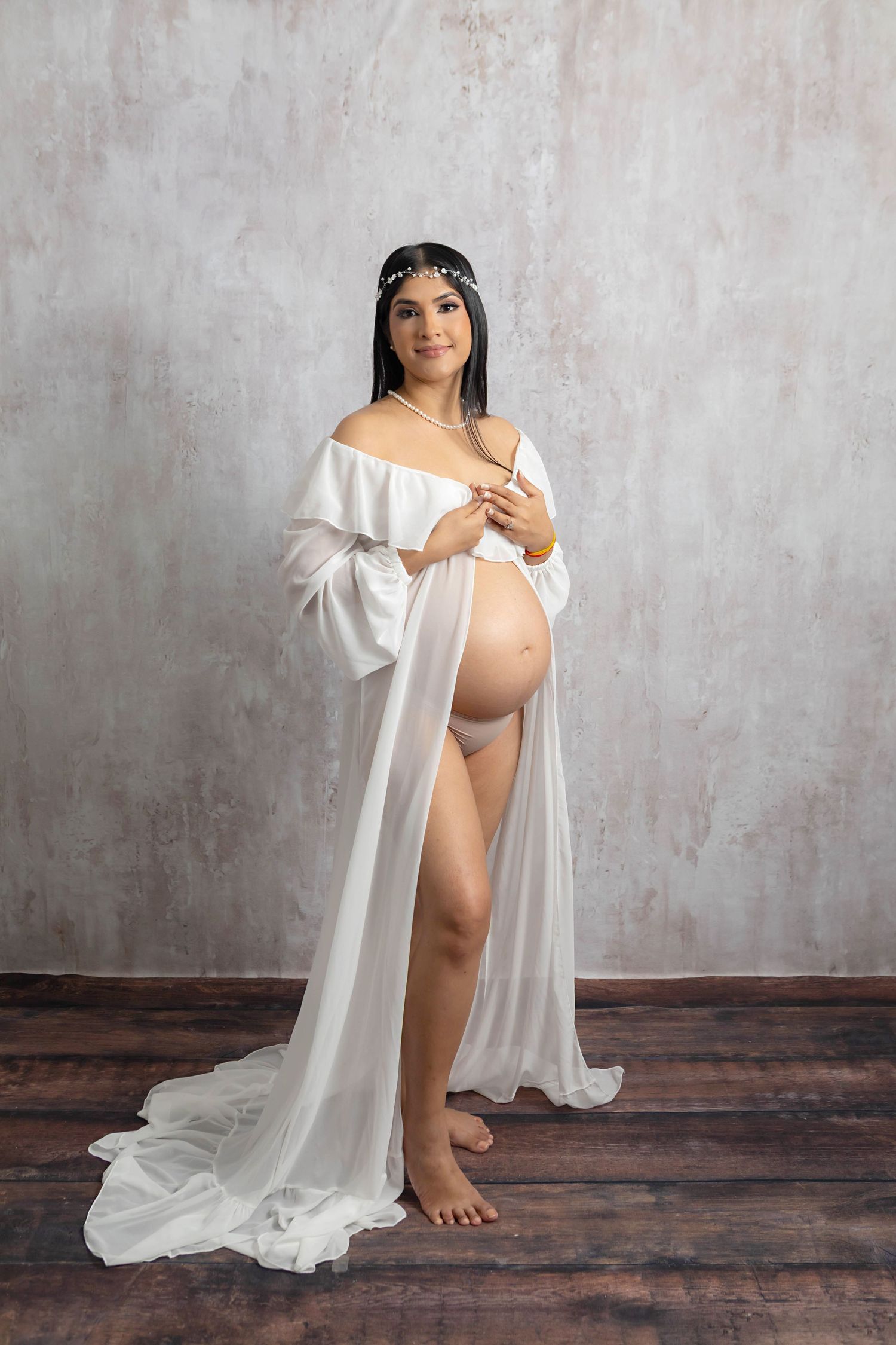 Pregnant mama wearing white posing with textured white backdrop