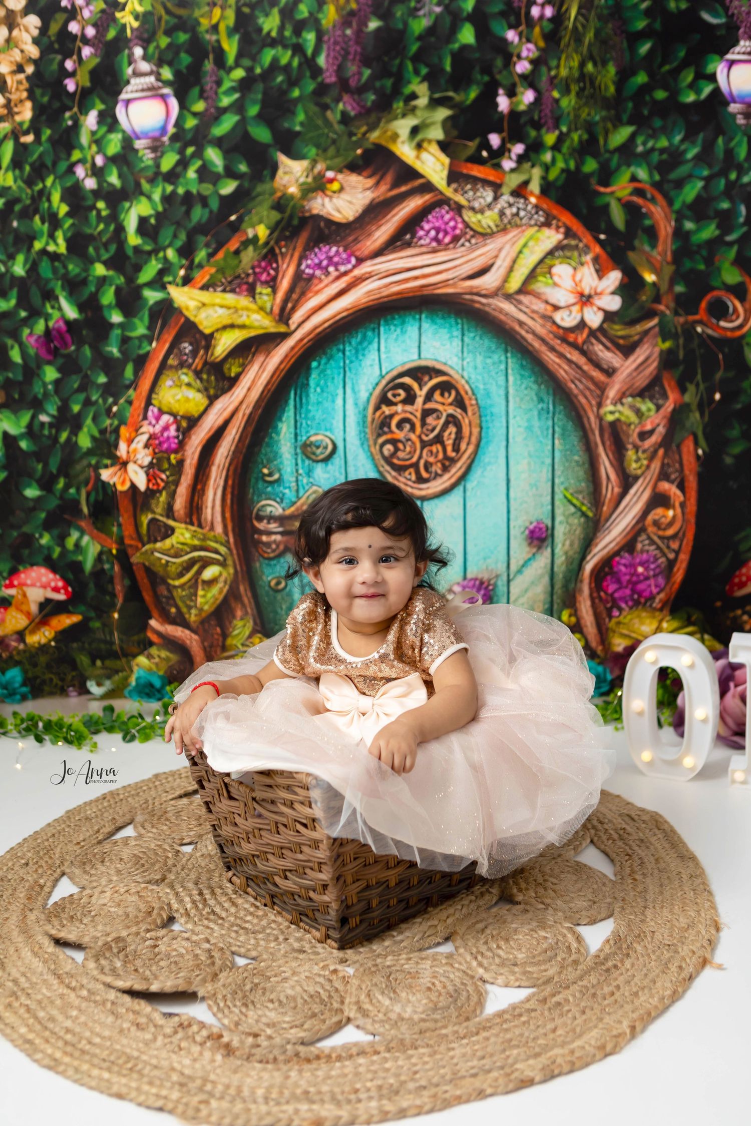 Enchanted forest themed backdrop. Baby girl all smiles in a basket.