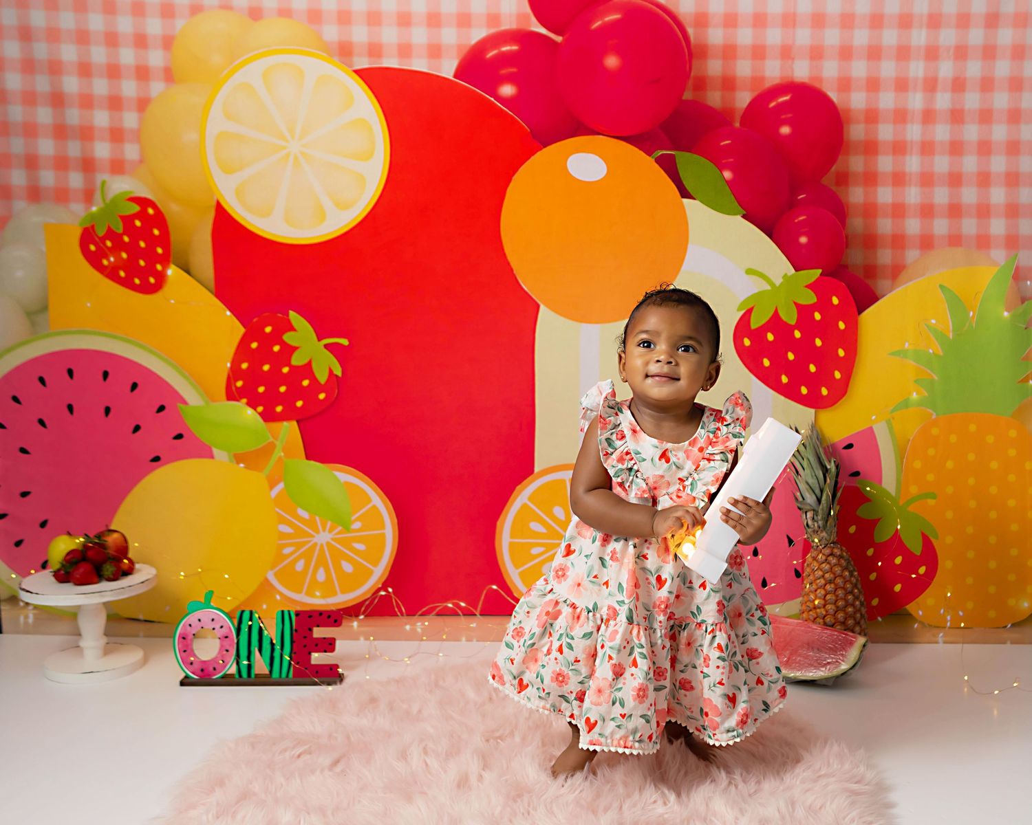 Fruit themed first birthday photos with baby girl holding a number 1