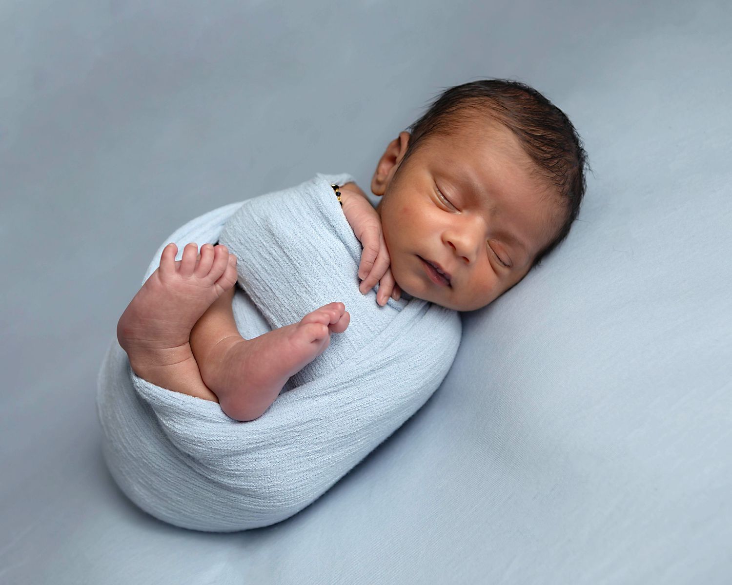 Simple classic posing of newborn baby boy in blue