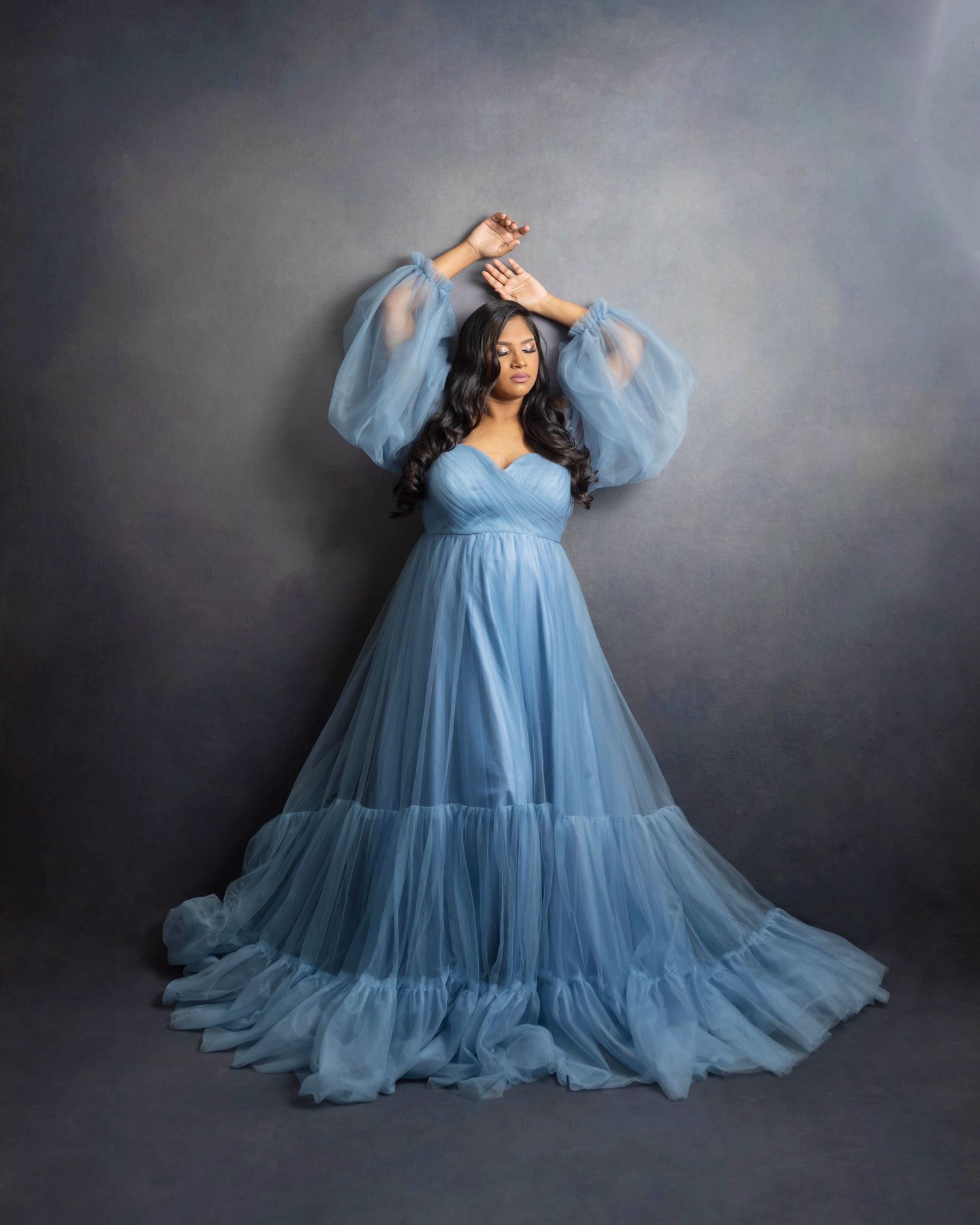 Pregnant boy mom in blue against a charcoal backdrop