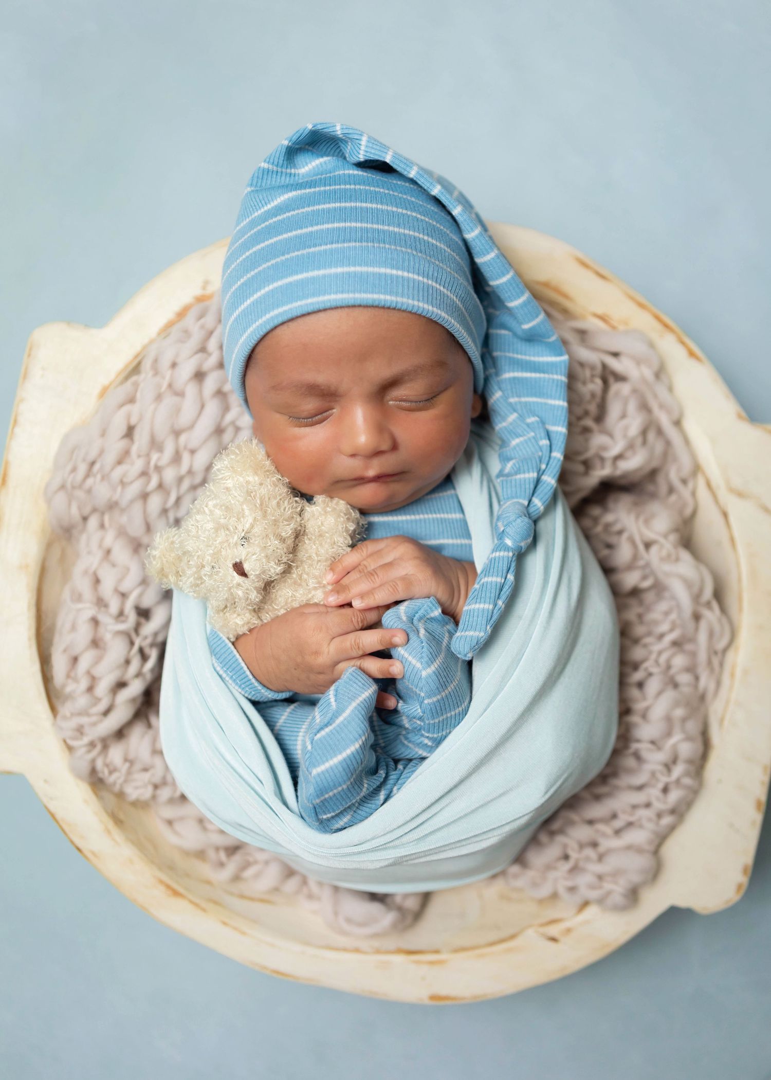 Newborn boy styled in blue and neutral colors