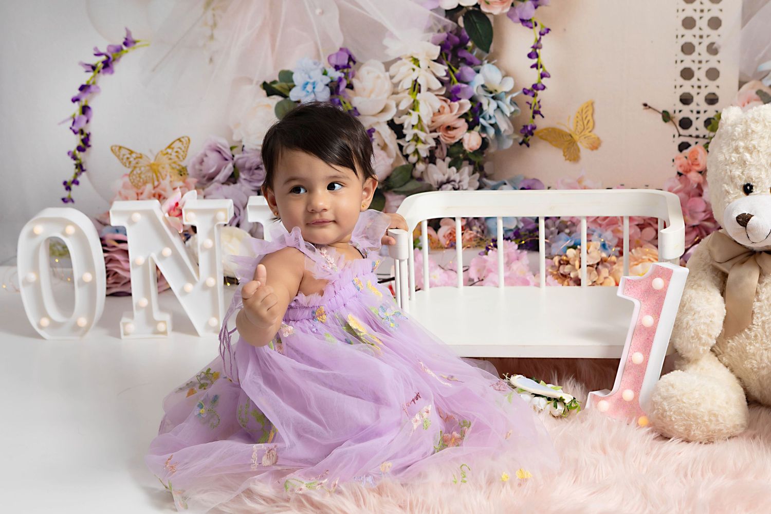 First birthday photos of a baby girl using a fairy themed set