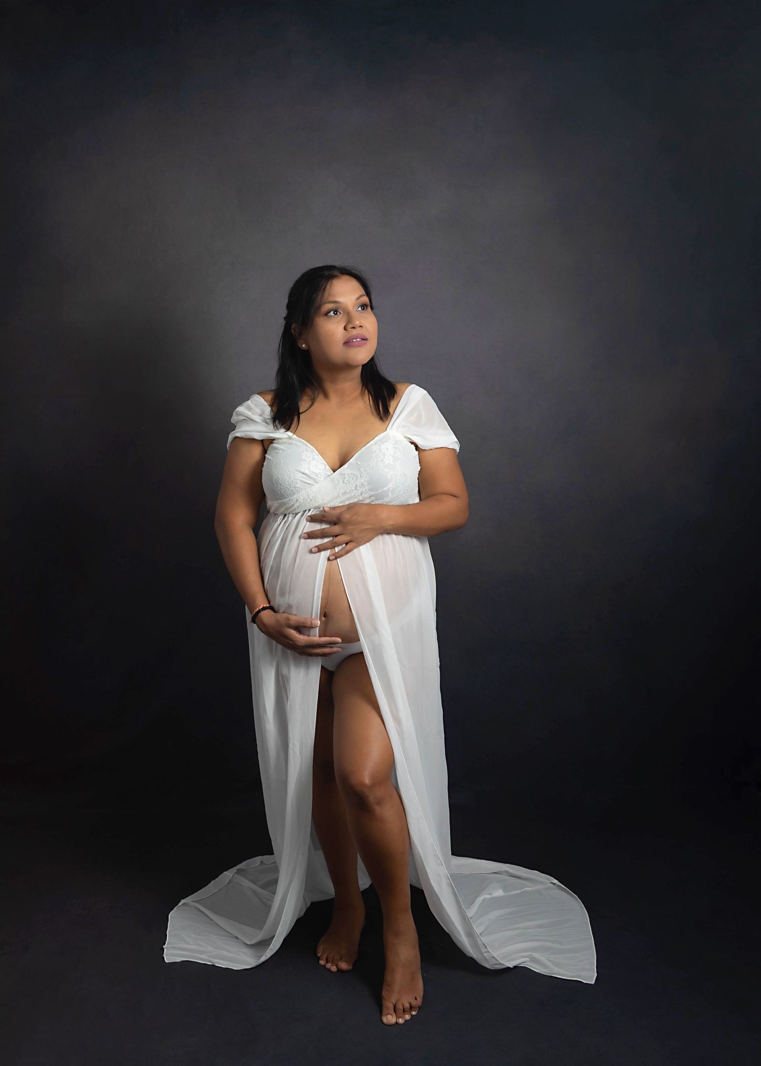 Pregnant boy mom in white simple dress against a charcoal backdrop