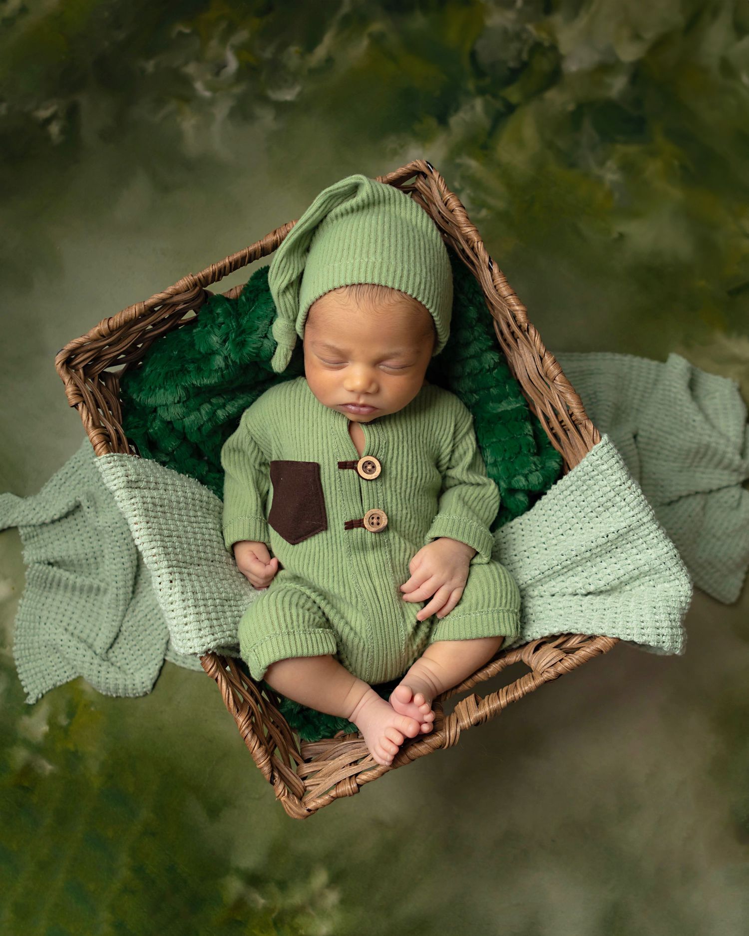 baby boy posed in green on a green backdrop