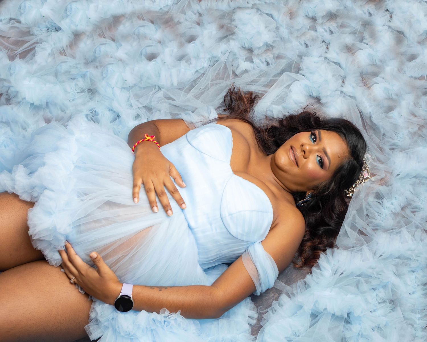 boy mom posed lying on the ground cradling her belly
