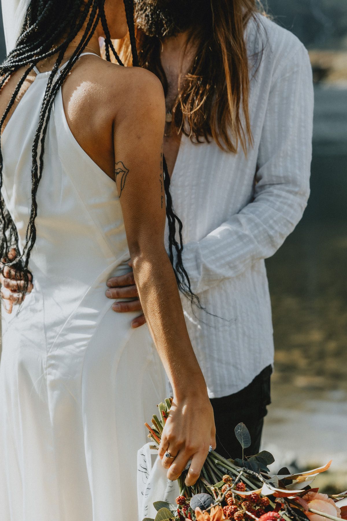 Couple embracing during an intimate elopement in North Wales with mountains in the background, photographed in a natural documentary style.