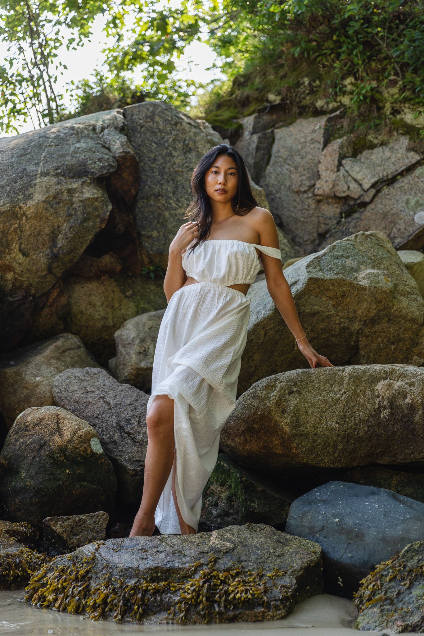Artistic shots of a white flowing dress against coastal rocks and water.