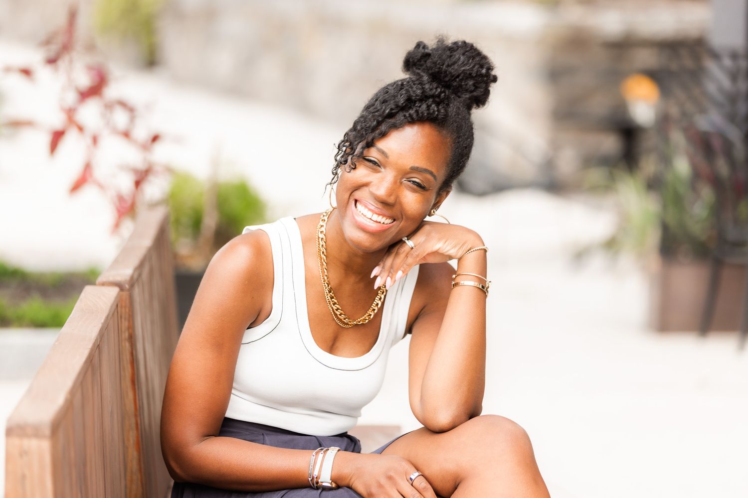 Casual outdoor portraits of a person wearing a white tank top and gold chain necklace.