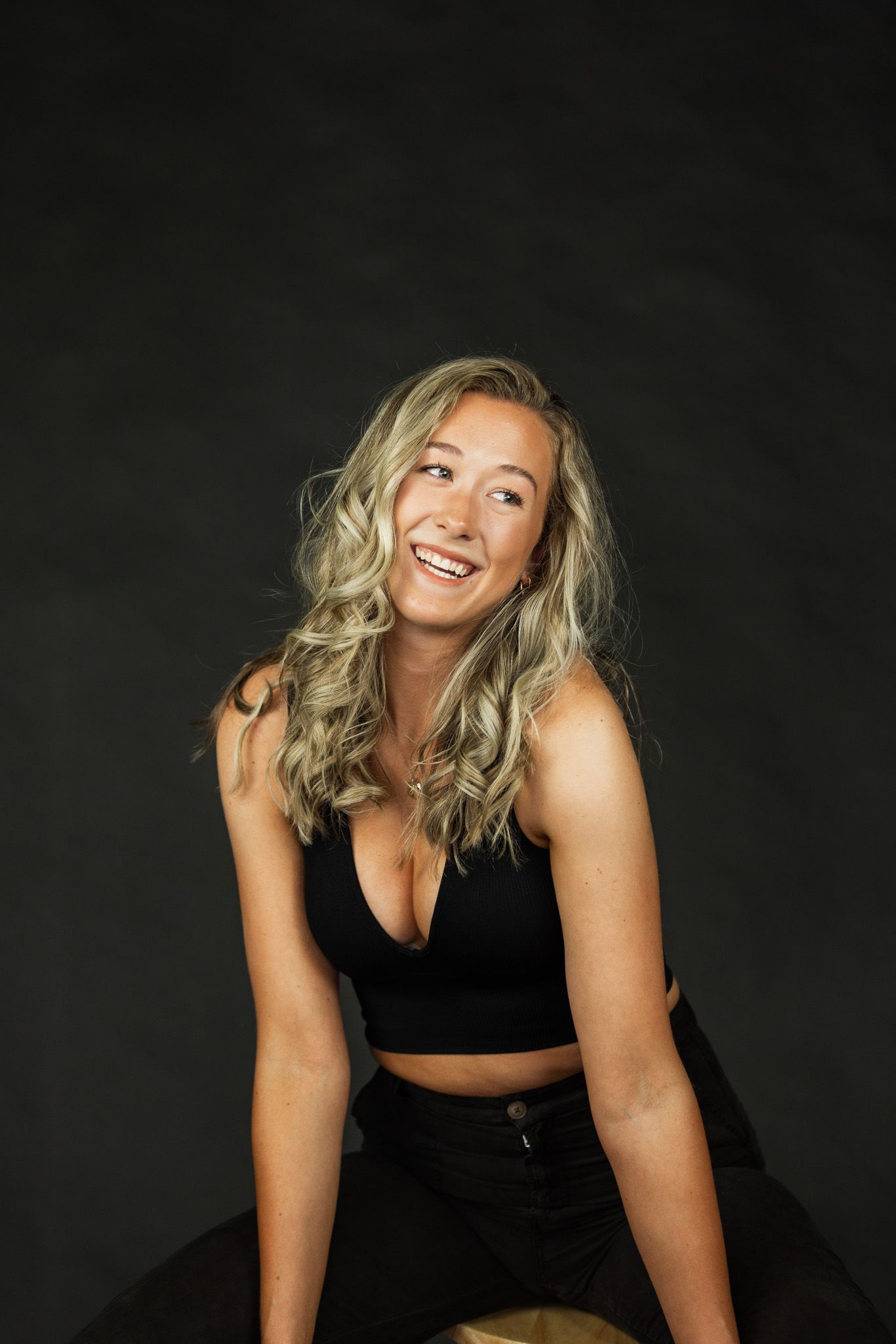 Professional studio portraits showing dynamic poses against a dark background in black attire.