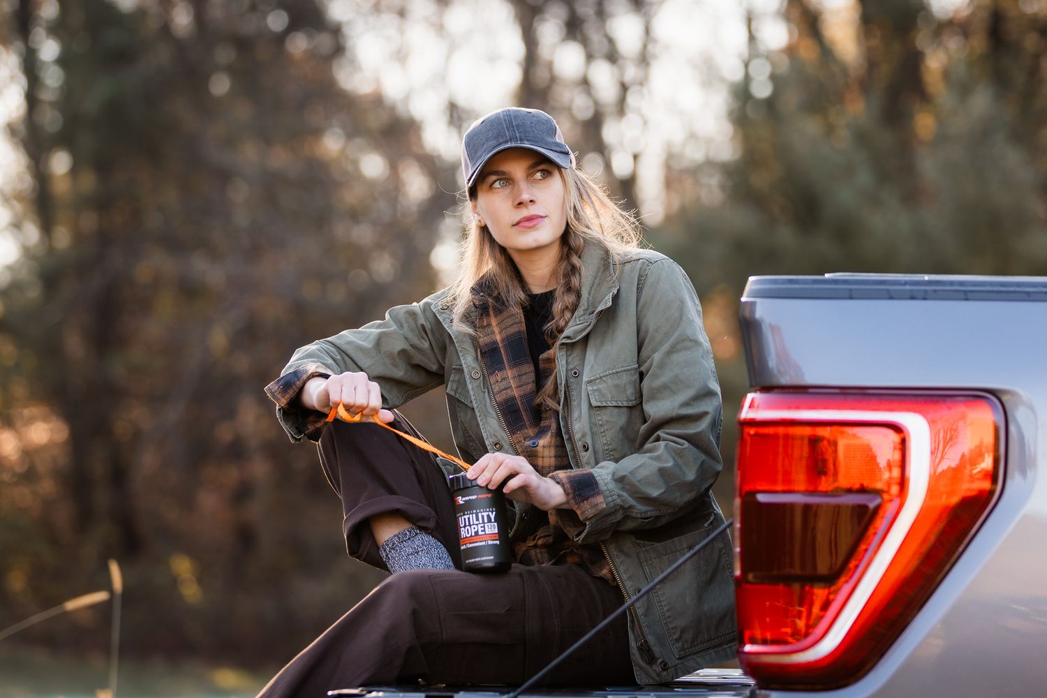 Side view of someone relaxing on pickup truck bed at sunset.