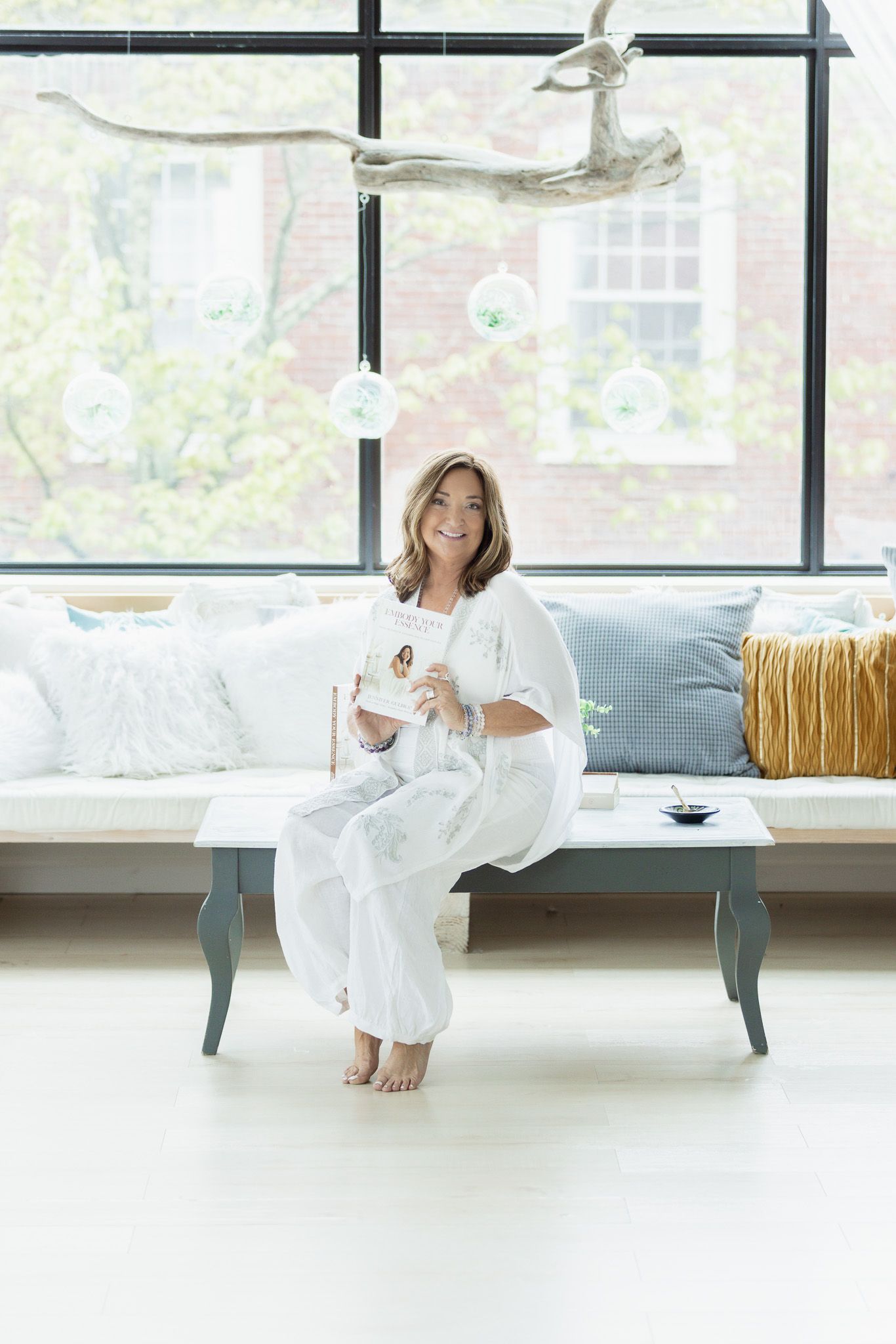 Interior scene with a white sofa and large windows in a bright modern space.