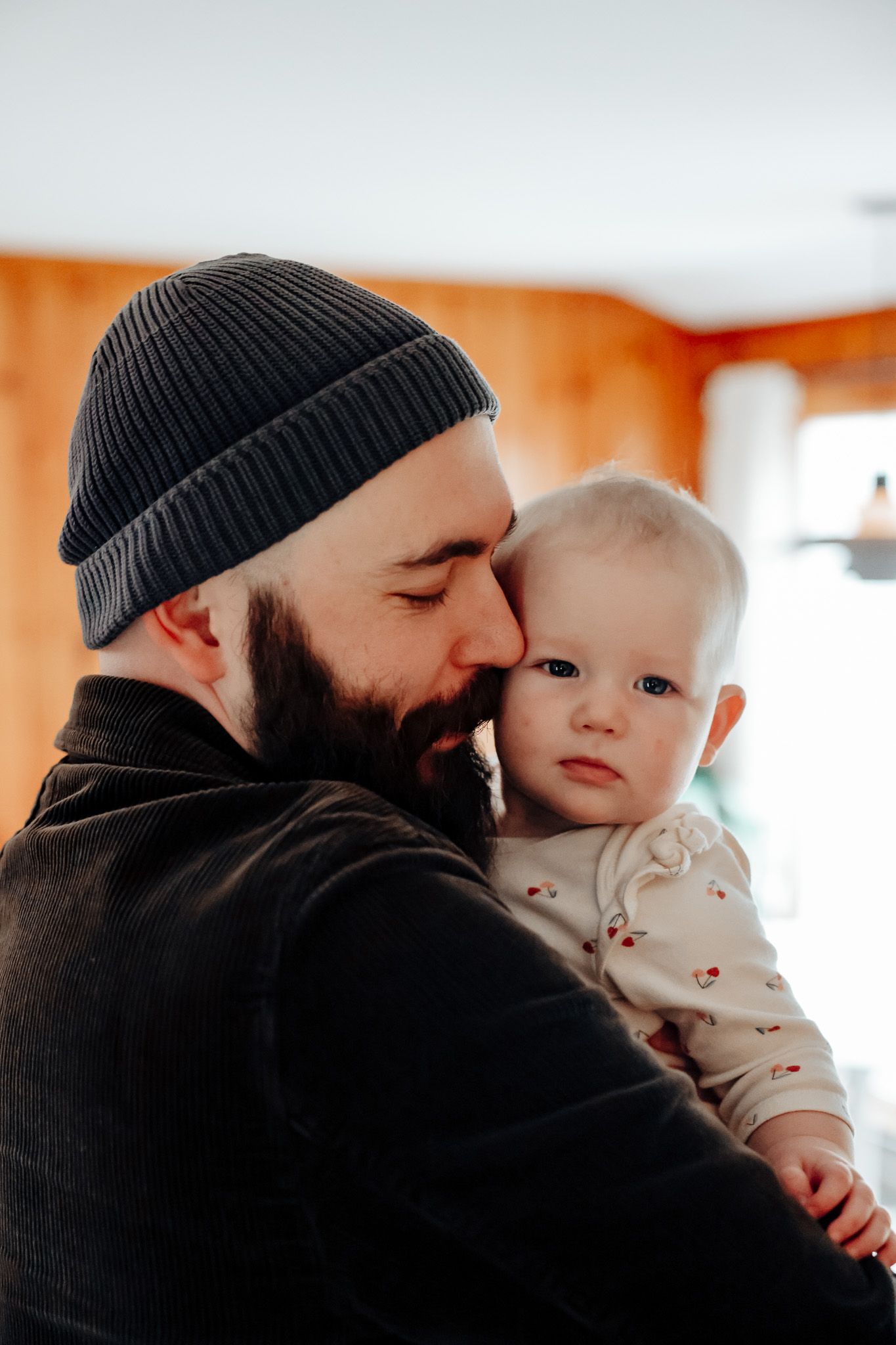 Intimate moment between parent and infant wearing a white onesie.