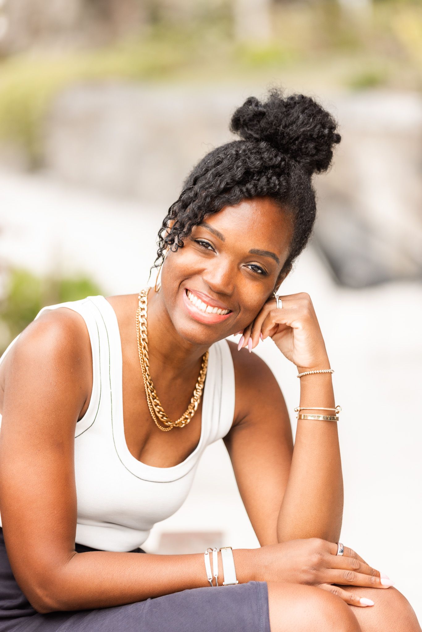 Professional headshots showing a person in a white tank top with gold jewelry against a light background.