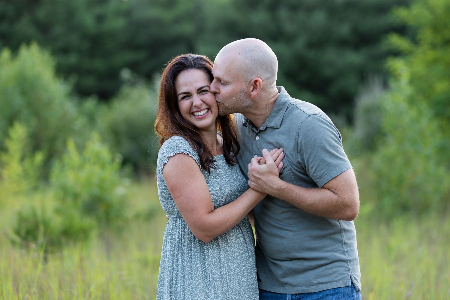 A parent and toddler share joyful moments in a sunlit field during golden hour.