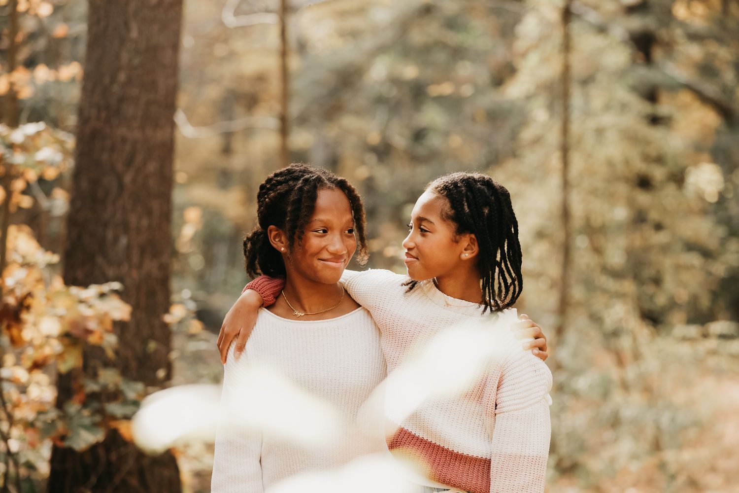 Family members share joyful moments and laughter while posing in coordinated outfits outdoors.