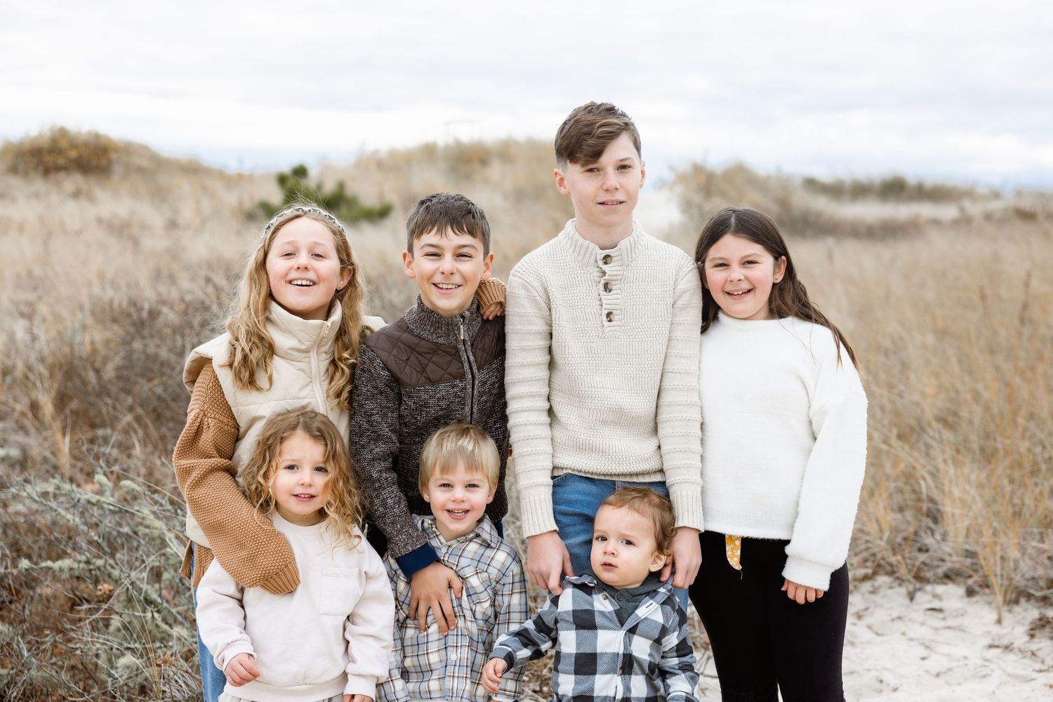 Family group photo in neutral tones against a natural winter landscape.