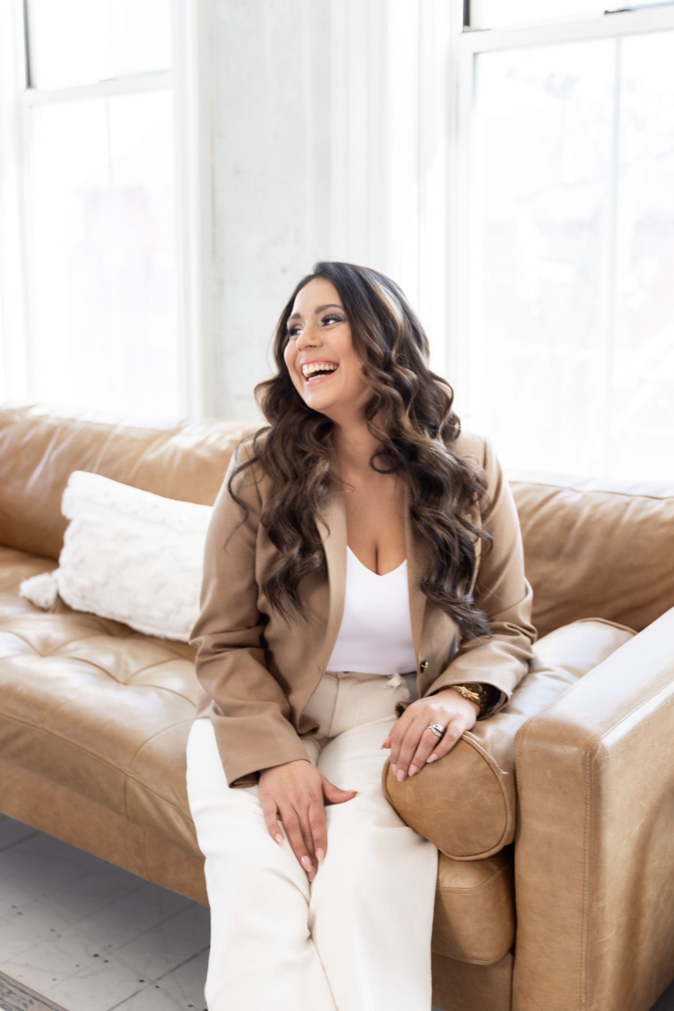 Lifestyle photography on tan leather couch in bright white room.