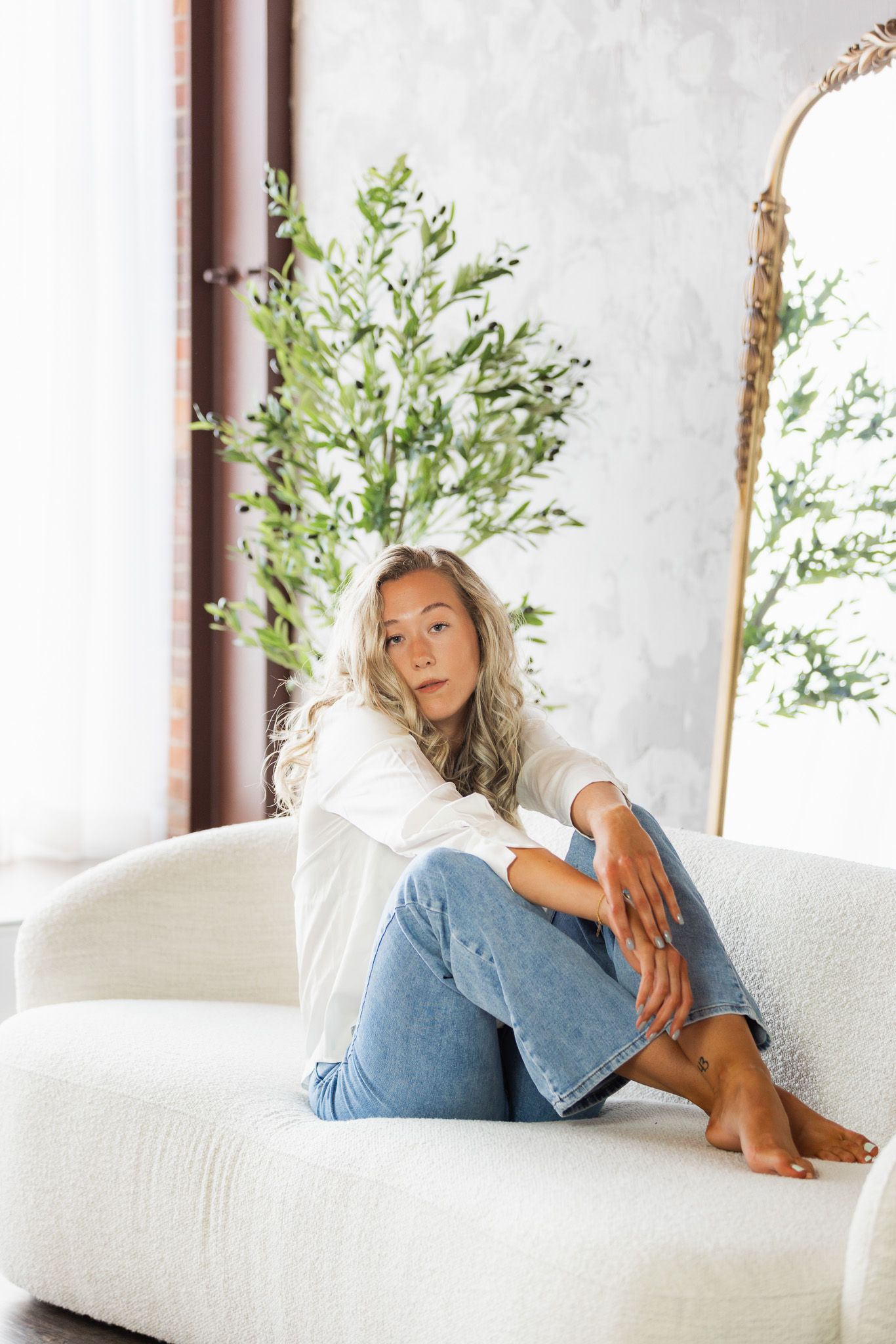 Lifestyle portraits on a white couch with natural greenery in background.