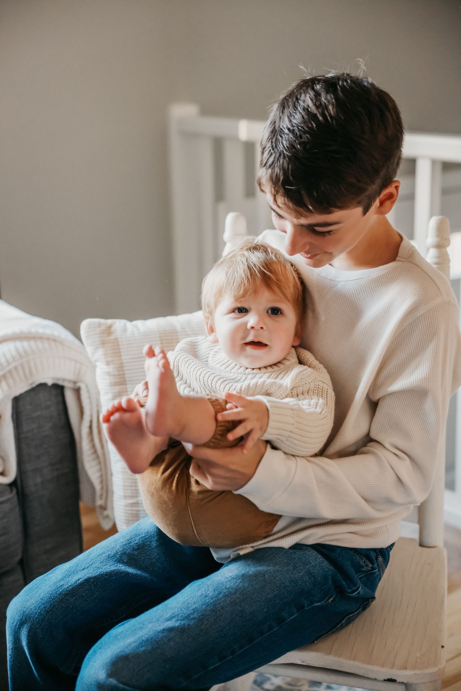 Casual lifestyle moment captured on white chair showing playful interaction.