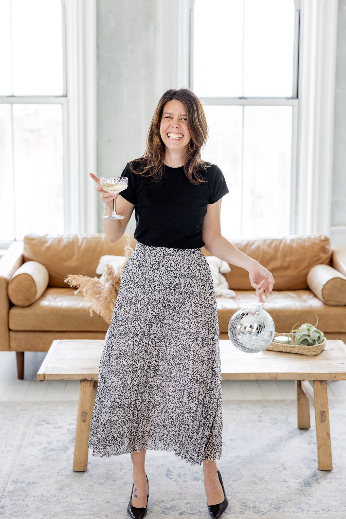 Fashion portraits showing twirling motion in black top and patterned skirt.
